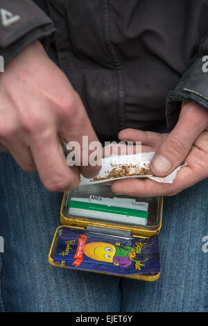 Un uomo di laminazione di un giunto usando felice Joker, un legale alta Foto Stock