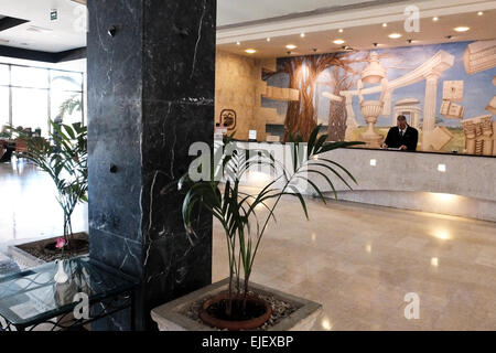 Un receptionist mans la reception dell'Occidental Miramar Hotel a L'Avana, Cuba. Foto Stock