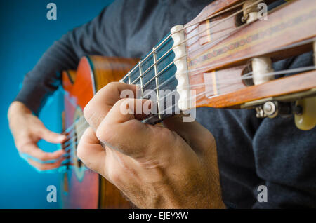 Primo piano di un uomo di colore rosso suonare la chitarra classica in concerto con le dita, concentrarsi sulla sinistra. Foto Stock
