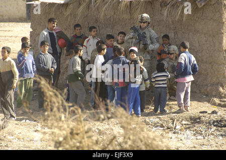 Stati Uniti Army Sgt. Andrew McCann e PFC. Julian Pachecorojas, sia con il primo plotone, Bravo Company, 2° Battaglione, XXIII Reggimento di Fanteria, quarta brigata Team di combattimento, seconda divisione di fanteria, intrattenere un gruppo di bambini durante una catastrofe umanitaria aide goccia nel villaggio di Baloor, Iraq, Febbraio 4, 2008. Spc. LaRayne Hurd rilasciato Foto Stock