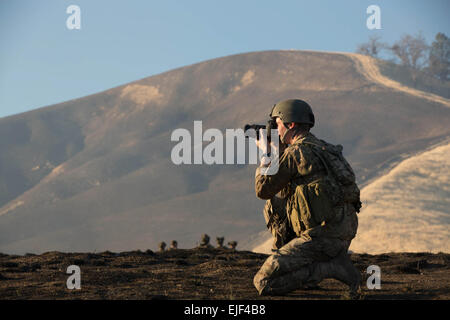 Stati Uniti Army Spc. Steven Hitchcock assegnato a 55th Signal Company combattere la fotocamera, prende fotografie durante una missione su Fort Hunter Liggett, California, 22 gennaio 2014. Hitchcock di missione era di Document Task Force formazione condotta da rangers dal 2° Battaglione, 75o Reggimento Ranger. Pfc. Mincy Rashene Foto Stock