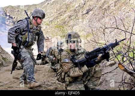 Stati Uniti I soldati dell esercito preparare per spostare dal coperchio durante un attacco da anti-forze afghane nel villaggio Tantil in Afghanistan orientale della provincia Kunar, 13 marzo 2010. I soldati sono assegnati a società D, 2° Battaglione, dodicesimo reggimento di fanteria. Forze di sicurezza nazionali afgane e sicurezza internazionale le forze di assistenza ha visitato la comunità e i suoi anziani in risposta ad un elevato numero di recenti attacchi nella zona. Il personale Sgt. Gary A. Witte Foto Stock