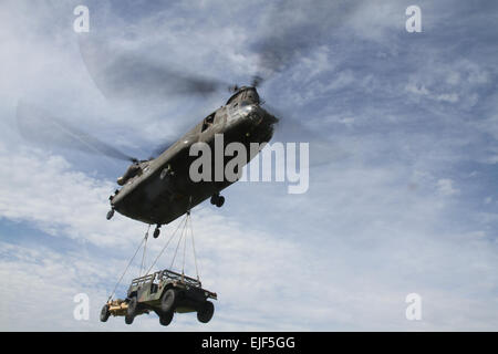 M119un obice leggero e la sua elevata mobilità multiuso di veicolo a ruote sono bloccati al fondo di un CH-47 Chinook e spostata in modo sicuro da Aviosuperficie Marshall in un altro luogo di formazione su Fort Riley, Kan., in un assalto dell'aria slingload esercizio condotta dal 2° Battaglione, XXXII Campo Reggimento di Artiglieria Sett 13. Stati Uniti Il personale dell'esercito Sgt. Gene Arnold, 4° IBCT Affari pubblici Foto Stock