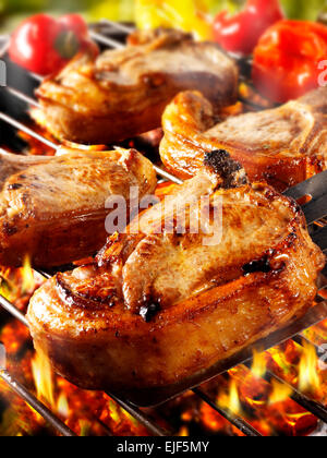 La cottura su un barbecue con carboni ardenti e costolette di agnello Foto Stock