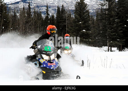 Stati Uniti Esercito mandato Officer Rick Fleming, a sinistra, E DEGLI STATI UNITI Il personale dell'esercito Sgt. Elaine Jackson, assegnato all'Alaska National Guard, tagliare attraverso la polvere fresca in preparazione per il 2010 Alaska National Guard Iron Dog gara di motoslitte, Camp Denali, Alaska, Feb 16, 2010. Alaska National Guard foto di U.S. Pfc dell'esercito. Karina Paraoan Foto Stock