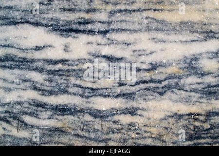 Primo piano di marmo texture con macchie di glinting quarzo e vene di pietra scura Foto Stock