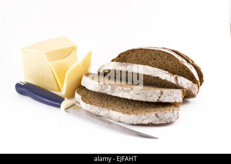 Marrone a fette della pagnotta di pane con un coltello e tagliare le fette di formaggio Foto Stock