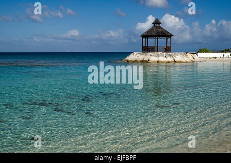 Acque calde e cristalline, cielo blu, e una spiaggia da gazebo. Foto Stock