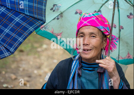 Donna Hmong con un ombrello in un mercato di Sapa, Vietnam Foto Stock