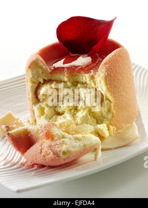 Il cioccolato bianco torta con un caso di spugna e fragola il riempimento, coperto con rosa bianco cioccolato in polvere Foto Stock