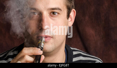 Un giovane uomo con una sigaretta elettronica Foto Stock