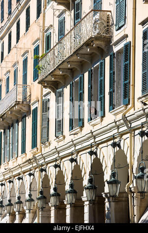 Donna alla finestra sopra le arcate e lanterne tradizionali del famoso Liston presso la Spianada in Kerkyra, citta di Corfu, Grecia Foto Stock
