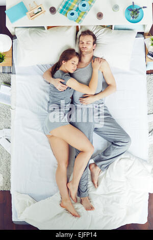 Angolo di Alta Vista del giovane nel letto Foto Stock