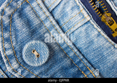 Pulsante di jeans angolo inferiore sinistro con parte della tasca e zip sulle pale blue jeans tessuto. Jeans stile di design di moda. Foto Stock