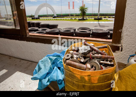 Bullone e dado in una scatola sopra il tavolo. Circuito Karting workshop Foto Stock