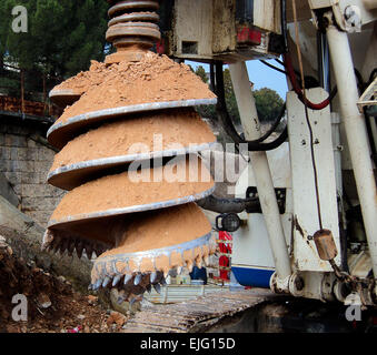 Dettagli macchina di perforazione dei fori di trivellazione nel terreno durante la costruzione di opere stradali Foto Stock