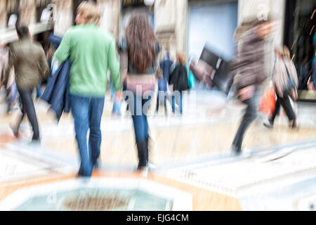 Shopper passato a piedi un negozio finestra, effetto di zoom, sfocatura del movimento Foto Stock