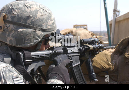 Stati Uniti Pfc dell'esercito. Robert Wimegar, con Alfa Company, 2° Battaglione, sedicesimo Reggimento di Fanteria, 2° Brigata Team di combattimento, 1° Divisione di Fanteria, tira la sicurezza sul tetto del consiglio del distretto Hall nel Mashtal area di East Baghdad, Iraq, 13 marzo 2007. Spc. Davis Pridgen rilasciato Foto Stock