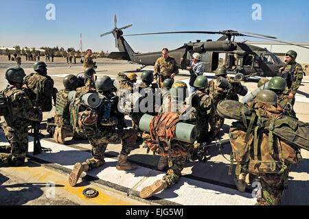 Un U.S. Esercito capo equipaggio, centro, mutandine soldati afgani sulle procedure per il carico e lo scarico di un UH-60 Black Hawk elicottero durante il carico statico di formazione per un assalto dell'aria missione guidata dalla Kandahar Air Wing in Afghanistan la provincia di Kandahar, Feb 29, 2012. Il soldato è assegnato a una società, 2° Battaglione, XXV Reggimento di aviazione, XXV Combattere la Brigata Aerea. Sgt. Daniel Foto Stock