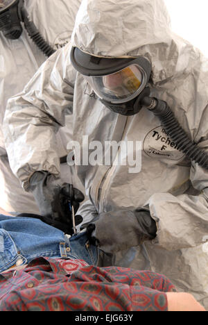 Stati Uniti Army Spc. Lee Leroy tagli gli indumenti contaminati da un finto vittima durante un esercizio a Camp Roberts, California, 17 aprile 2007. California Guardsman nazionale dal distacco 2, B Company, 579th Battaglione di Ingegneria sono la convalida di uno della California chimici, biologici, radiologici e nucleari e di alto esplosivo response force package squadre. Senior Master Sgt. Chris Drudge Foto Stock