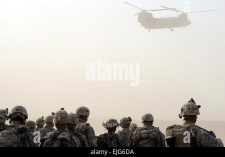 Paracadutisti dal primo plotone, la società C, 1° Battaglione, 501Reggimento di Fanteria, quarta brigata Team di combattimento, XXV divisione di fanteria, guardare come un CH-47 elicottero Chinook inizia la sua discreta durante una tempesta di polvere a inoltrare una base operativa Kushamond, Afghanistan, 17 luglio, in preparazione di un assalto dell'aria missione. Foto Stock