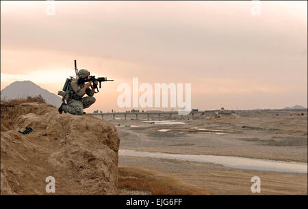 Spc. Nicholas Francioso, armored crewman, assegnato alla seconda squadra, 3° plotone, la società C., 1° Battaglione, 66reggimento blindato, 1° Brigata Team di combattimento, 4a divisione di fanteria, si inginocchia sulla cima di una scogliera che si affaccia sul fiume Arghandab Valley 31.01, di garantire la sicurezza per la sua squadra come essi salire sulla rupe dalla vallata sottostante. Francioso, nativo di Cleveland, Ohio, stava conducendo una pattuglia del piede con la sua squadra per cercare di frutteti di tutto il distretto e di interagire con la popolazione locale. Durante la loro pattuglie a piedi, seconda squadra deve manovrare il loro modo attraverso il Arghandab's molti ostacoli, incl Foto Stock