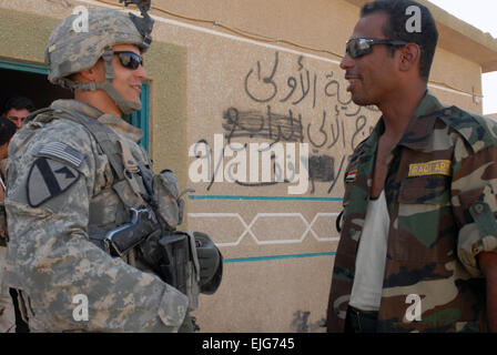 Austin, Texas, nativo, PFC. Zachary Sherman sinistra, una petroliera assegnata al 1° "Cavaliere Nero" Battaglione, quinto reggimento di cavalleria attaccata al 1° Brigata Team di combattimento, 1° Divisione di cavalleria, barzellette con un membro della sicurezza irachena vigore nel nord di Bagdad, 23 agosto. Sherman arruolati negli Stati Uniti Esercito nel dicembre 2007 per acquisire esperienza al fine di realizzare il suo sogno di diventare un ufficiale di polizia per il Boston il dipartimento di polizia. Photo credit: PFC. Bailey A. Jester. / / . Foto Stock