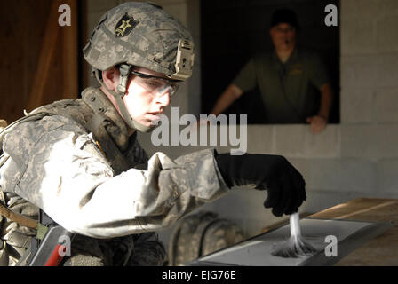 Spc. Austin Kidd, un poliziotto militare assegnato alla sede centrale e sede società, 4° Stryker Brigade Combat Team, seconda divisione di fanteria, cerca le impronte digitali a una simulazione della scena del crimine durante un materiale forense raccolta e lo sfruttamento corso giugno 23 a una formazione urbana sito qui. Sgt. Luisito Brooks, quarto SBCT, 2° Inf. Div. Ufficio per gli Affari pubblici Foto Stock