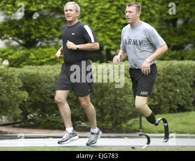 Il personale Sgt. Christian Bagge, che ha perso le gambe in Iraq lo scorso anno quando una bomba sul ciglio della strada ha colpito il suo Humvee, corre con il Presidente Bush il 27 giugno sul prato Sud della Casa Bianca. William D. Moss. . Foto Stock