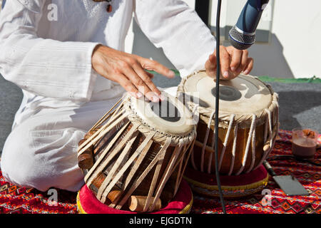 L'uomo gioca sulla tradizionale tabla indiane tamburi. Primo piano Foto Stock