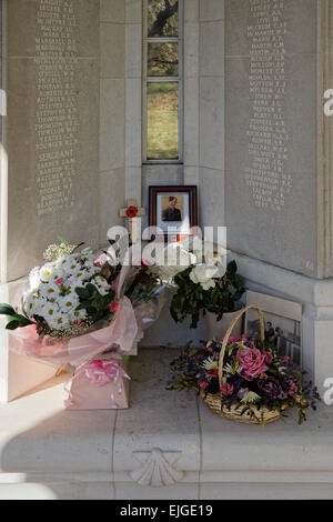 Omaggi, cross & fiori accanto a pannelli inscritto alla Air Forces Memorial Runnymede con fotografia del pilota commemorato Foto Stock