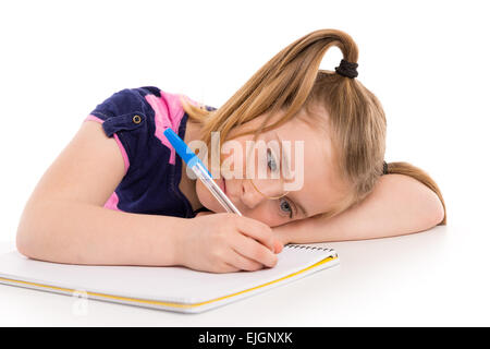 Blonde kid frastagliata una studentessa con notebook a spirale nel banco della pupilla Foto Stock