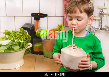 Adorabile ragazzo giovane bere acqua di cocco Foto Stock