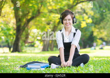 Giovane bella donna asiatica ascoltando la musica nelle cuffie Foto Stock