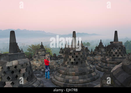 Tourist fotografare il Borobudur all'alba, sito Patrimonio Mondiale dell'UNESCO, Magelang, Giava centrale, Indonesia Foto Stock