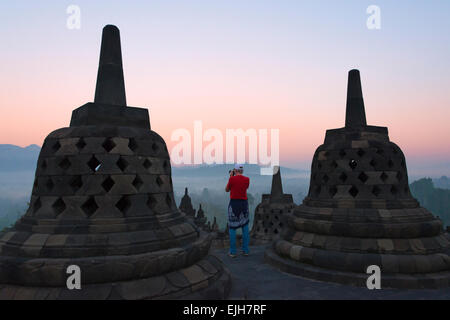 Tourist fotografare il Borobudur all'alba, sito Patrimonio Mondiale dell'UNESCO, Magelang, Giava centrale, Indonesia Foto Stock