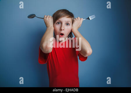 Ragazzo adolescente aspetto europeo in una maglietta rossa Mettere forcella e spo Foto Stock