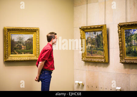 L'uomo ammirando la pittura impressionista nel museo di Orsay a Parigi, Francia Foto Stock