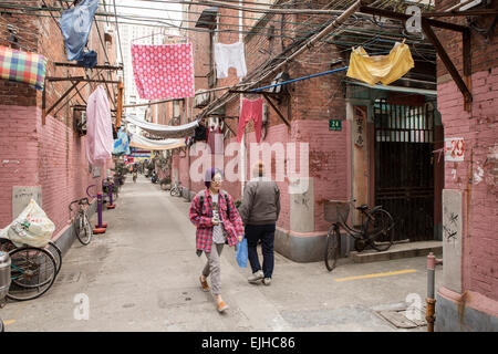 Residenti a piedi attraverso un antico quartiere residenziale nel centro cittadino di Shanghai, Cina Foto Stock