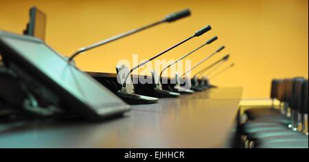 Tavolo da conferenza, microfoni e sedie da ufficio, closeup, arancione Foto Stock