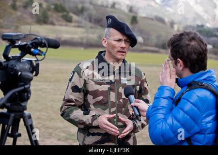 Il comandante della montagna di fanteria reggimento di ricognizione, Armel Dirou (l), parla a un membro della stampa in Seyne Les Alpes, Francia, 26 marzo 2015. Circa 40 soldati delle sue truppe aveva fissato il perimetro della collina circostanti cime durante una visita del Cancelliere tedesco Angela Merkel, Prsident francese François Hollande e il Primo Ministro spagnolo Mariano Rajoy quando sono arrivati a controllare il sito del crash di Germanwings volo 4U 9525 il 25 marzo 2015. Il focus è ora impostato su durante il recupero della scatola nera della Germanwings aeromobili A320 che si schiantò nelle Alpi francesi, sud della Francia su 24 ma Foto Stock