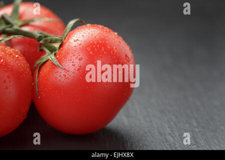 Mature Lavate i pomodori sulla vite su sfondo di ardesia Foto Stock