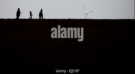 Lafferde lordo, Germania. 26 Mar, 2015. Una famiglia passeggiate in misty meteo su un paese lane passato turbine eoliche vicino al lordo Lafferde, Germania, 26 marzo 2015. Foto: Julian Stratenschulte/dpa/Alamy Live News Foto Stock