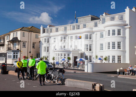 Un gruppo di ciclisti pongono di fronte alla facciata elegante dell'Hotel Riviera sul lungomare a Sidmouth, nel Devon, Inghilterra, Regno Unito Foto Stock