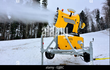 Giallo cannoni da neve sulla pista da sci. Foto Stock