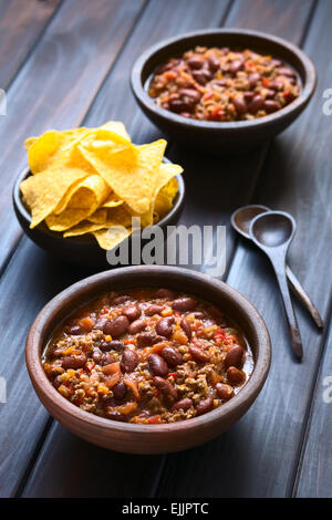 Due ciotole rustico di chili con carne con tortilla chips nel retro, fotografati con luce naturale (messa a fuoco selettiva) Foto Stock