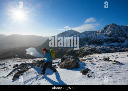 Inverno walker al di sopra del Lough Cruite sulle pendici della montagna di Brandon, penisola di Dingle, nella contea di Kerry, Irlanda. Foto Stock