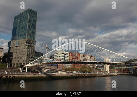 Il Footbridge Zubizuri attraverso il fiume Nervion guardando verso il Museo Guggenheim a Bilbao, Spagna Foto Stock