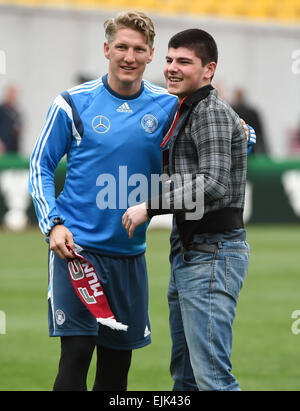 Tbilisi, Georgia. 28 Mar, 2015. La Germania Bastian SCHWEINSTEIGER (L) abbraccia un sostenitore georgiano durante una sessione di formazione a Tbilisi, Georgia, 28 marzo 2015. La Germania dovrà affrontare la Georgia nella UEFA EURO 2016 GRUPPO D qualifica partita di calcio il 29 Marzo a Tbilisi. Foto: Arne Dedert/dpa/Alamy Live News Foto Stock