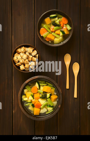 Tettuccio di colpo di due ciotole rustico di origine vegetale zuppa di zucchine, verde fagiolo, carote, broccoli, patate e zucca Foto Stock